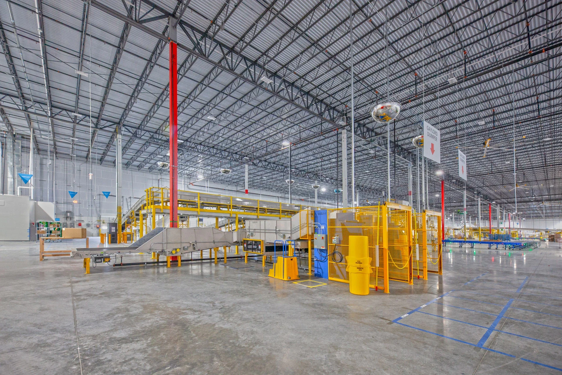 Interior tenant buildout at a fulfillment center with installed conveyor equipment.